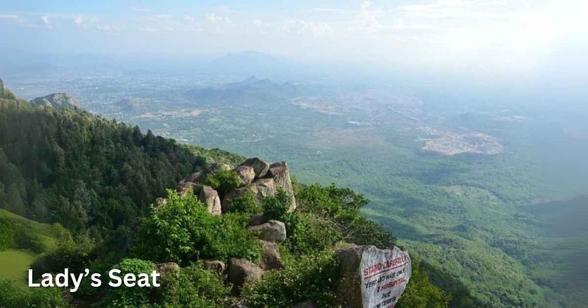 Elevated rock viewpoint at Lady’s Seat overlooking a vast green valley and distant hills.