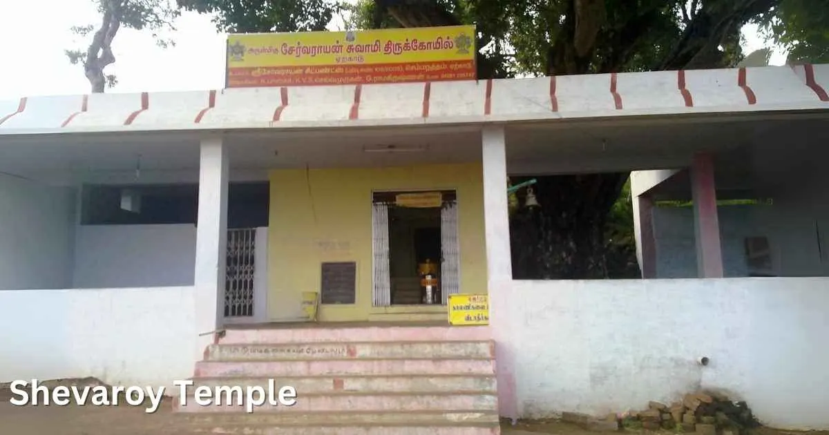 Simple exterior of Shevaroy Temple with a yellow and white painted entrance, located on a hilltop.