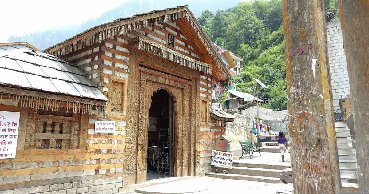 "A traditional wooden temple with intricate carvings, located in a mountainous village in Himachal Pradesh, India."