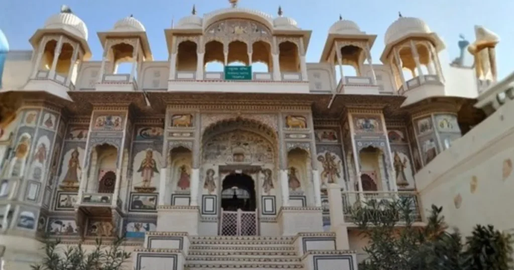 Exterior facade of the Raghunath Temple in Mount Abu, featuring Mewar-style architecture and colorful wall paintings.